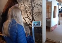 Kinder betrachten ein Video am Tablet im Museum